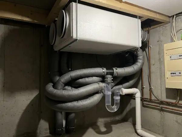 Geïsoleerde kanalen en condensafvoer onder een ventilatie-unit